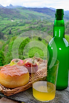 Natural Asturian cider made fromÂ fermented apples and Asturian cow smoked and view Picos de Europa mountains on background